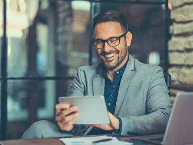 Man smiling while browsing tablet