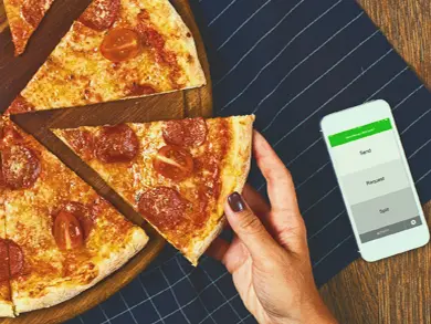 women taking a slice of pizza