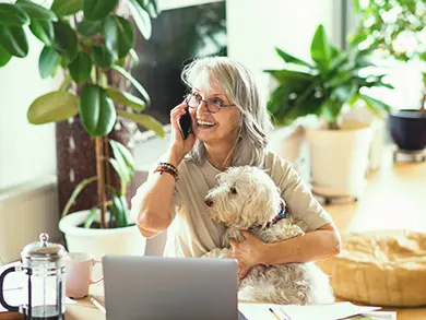 Elderly women talking on the phone while holding her dog