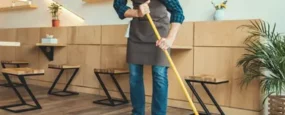 Man sweeping with a broom indoors