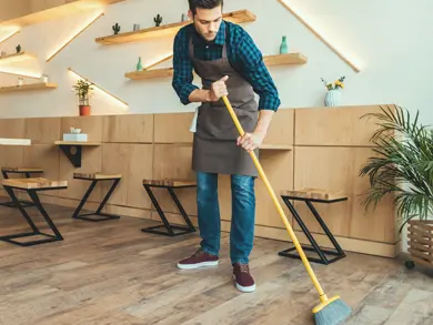 Man sweeping with a broom indoors