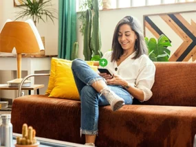 A woman holding a phone with a visual of a plus sign for Central Plus Checking