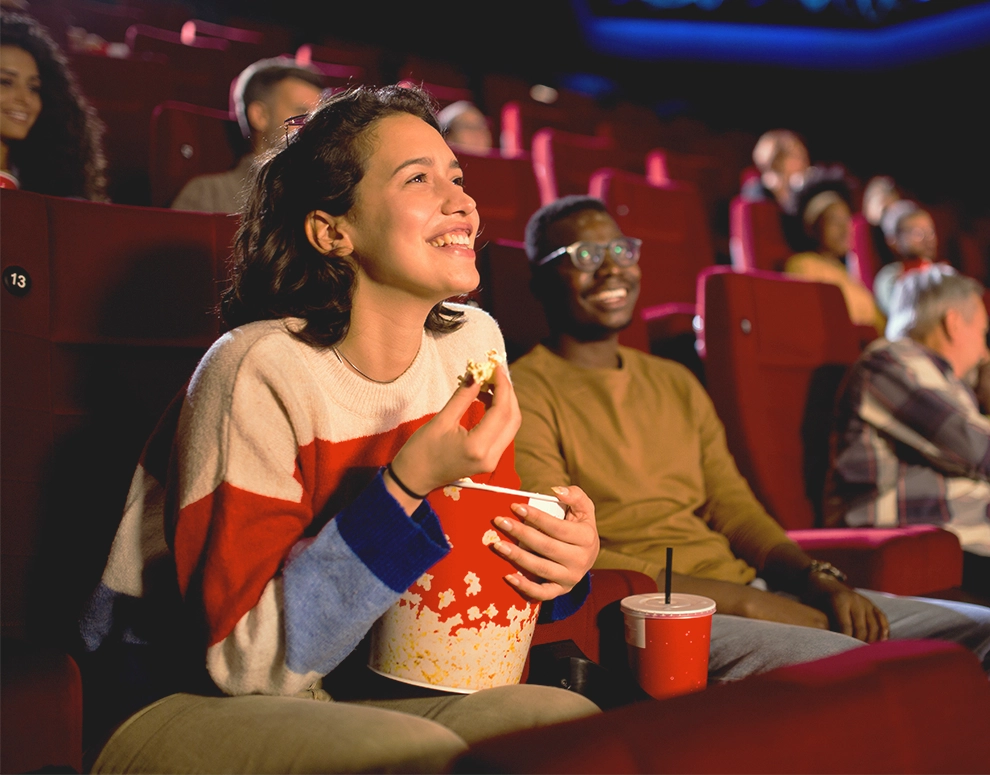 Una mujer viendo una película en el cine.