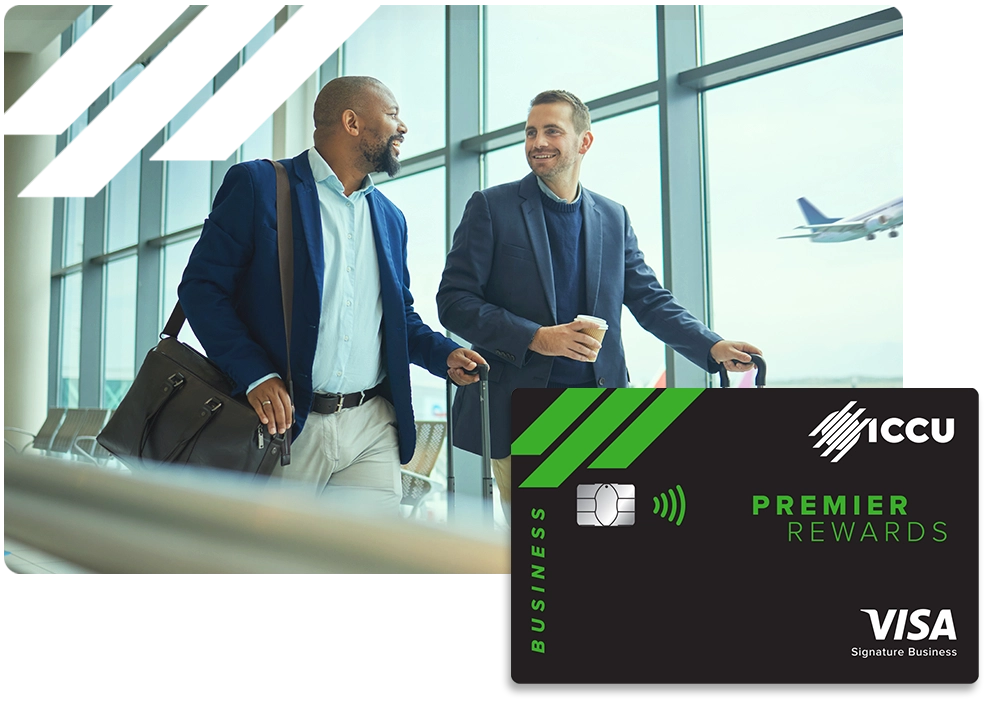 Dos hombres trajeados en el aeropuerto con un gráfico de la tarjeta de crédito Premiere Rewards de ICCU Business