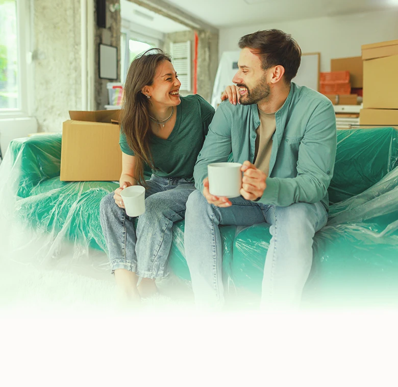 Couple relaxing on a green couch with ongoing home renovations in the background