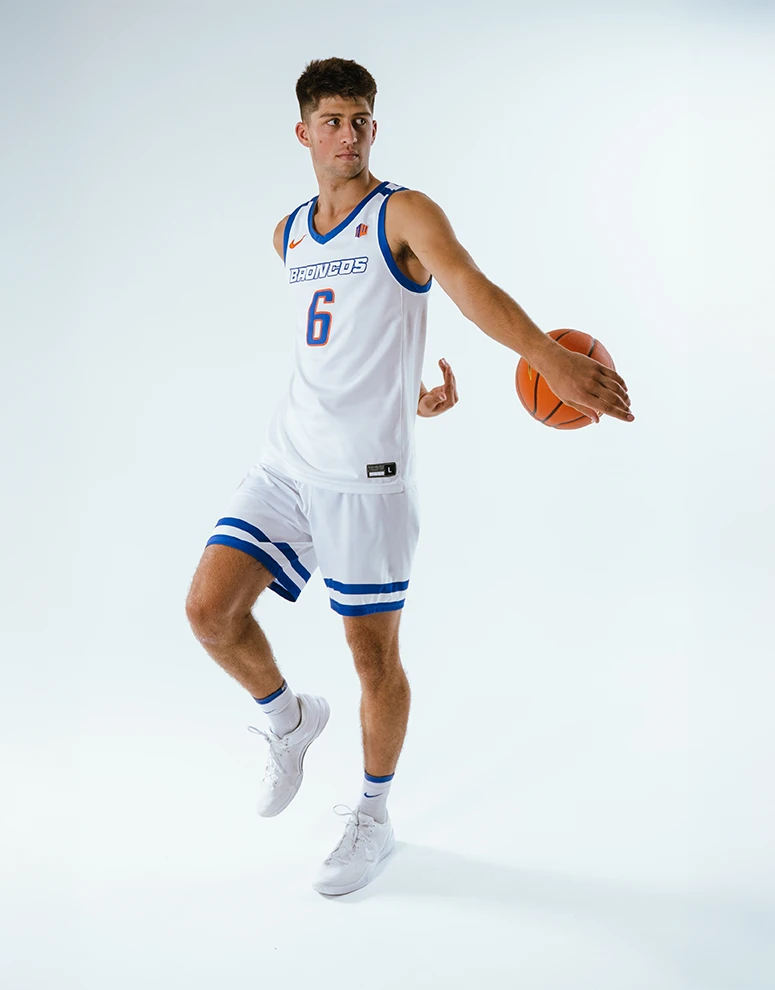 Pearson Carmichael executes high-energy basketball moves in a studio photoshoot, capturing his skill and athletic form.