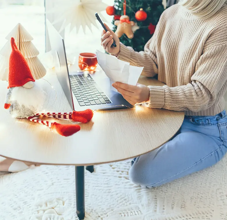 Person sitting at a round wooden table with a laptop